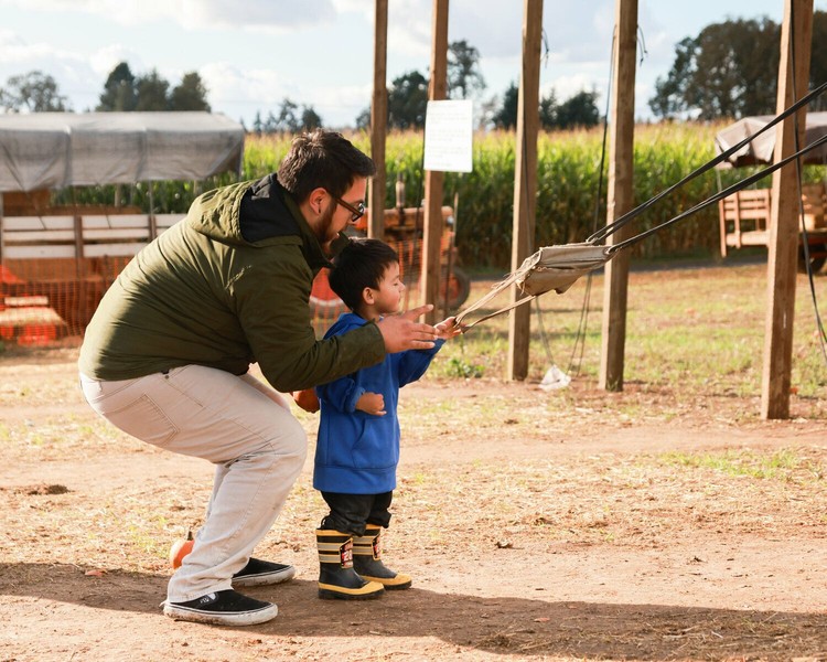 Jose and Xeleus Flores of Vancouver attempt to launch a mini pumpkin into a barrel at the Bi-Zi Farms pumpkin patch in Brush Prairie in 2024.