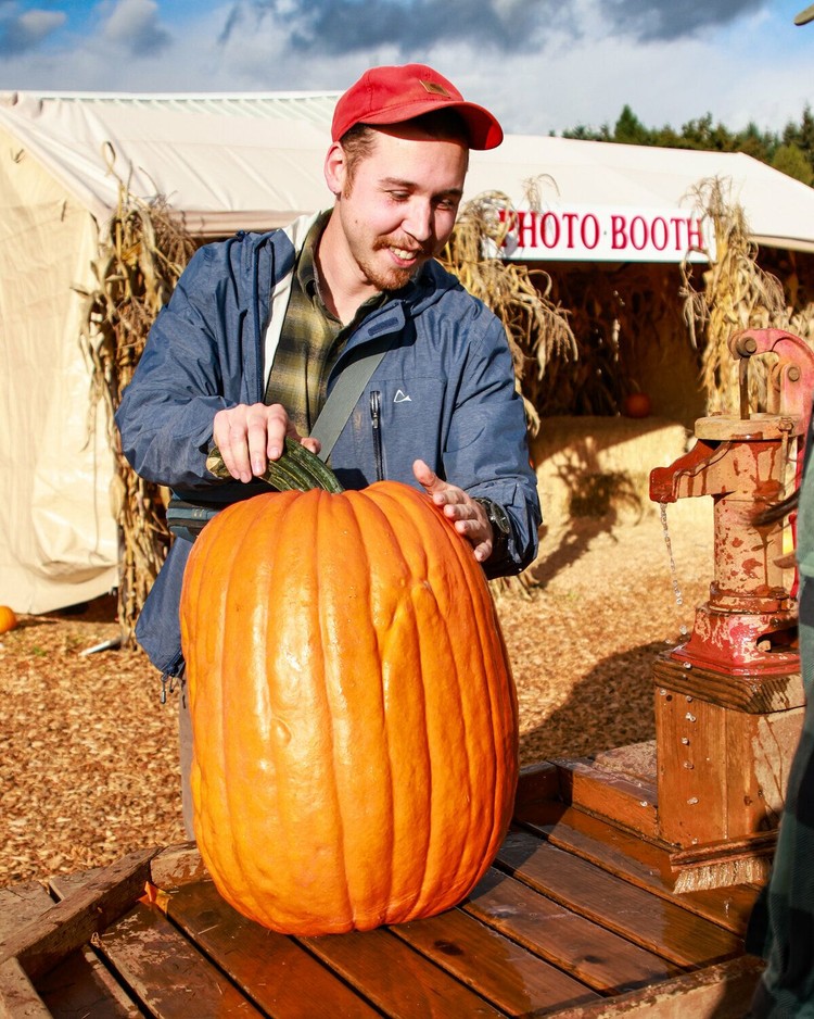 Brandon Bush of Vancouver washes his rather tall pumpkin he picked from the Bi-Zi Farms pumpkin patch in Brush Prairie in 2024.