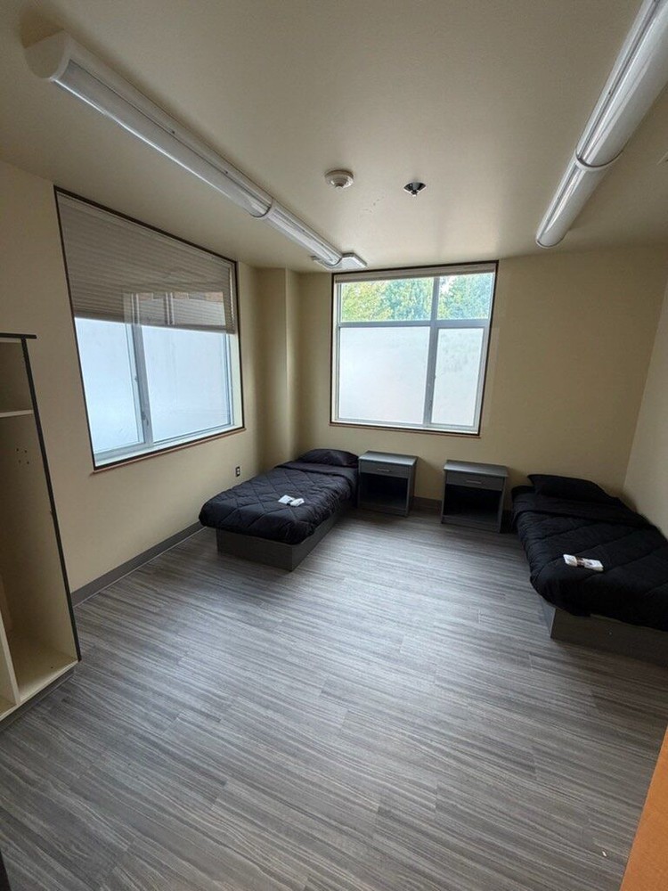 A dining space with a refrigerator and couch at The Landing Pad in Clark County.