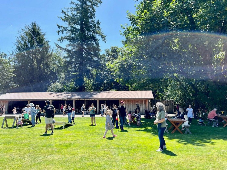 Visitors play lawn games and eat at tables at Pomeroy Historic Living Farm.
