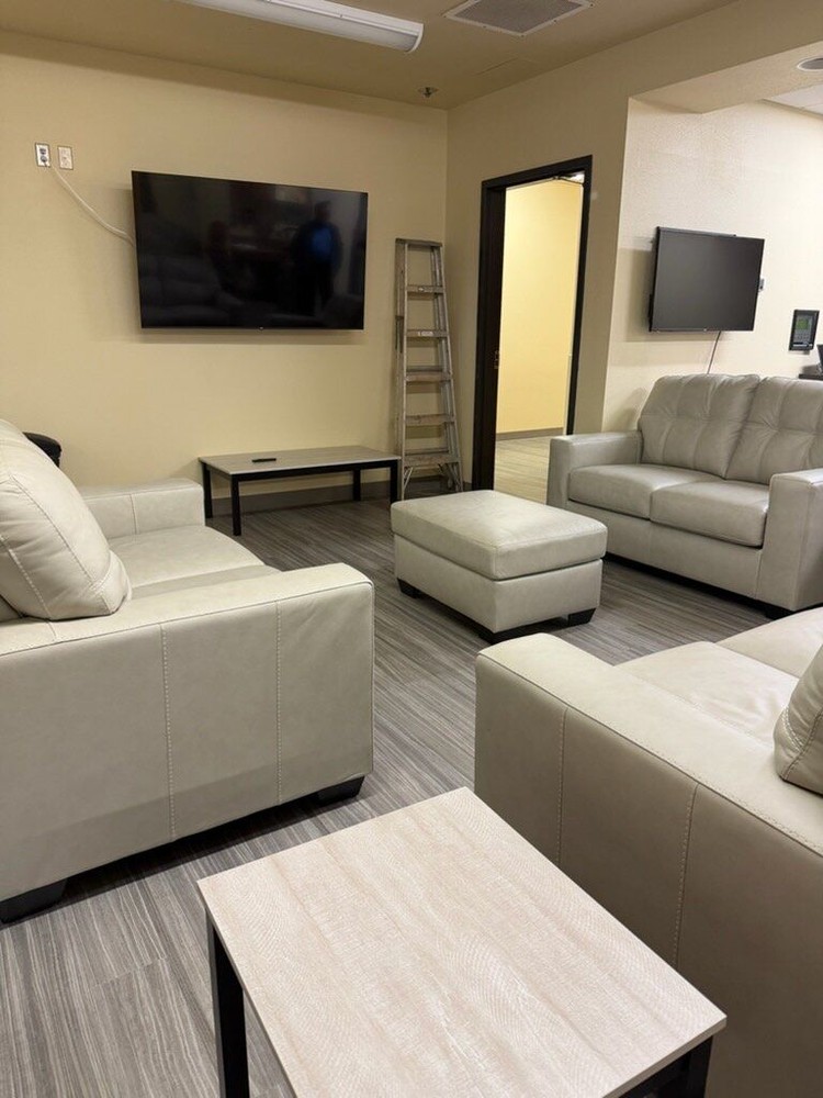 A living space with couches, side tables and a foot rest at The Landing Pad in Clark County.