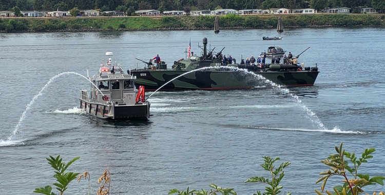 A Vancouver Fire boat gives a water salute next to a restored PT Boat on the Columbia River on Friday, part of the 9/11 Patriot Day Salute